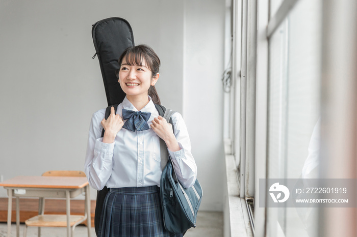 学校の教室で楽器・ギターを持った軽音部・吹奏楽部の高校生・中学生・女子高生（制服・バンド）