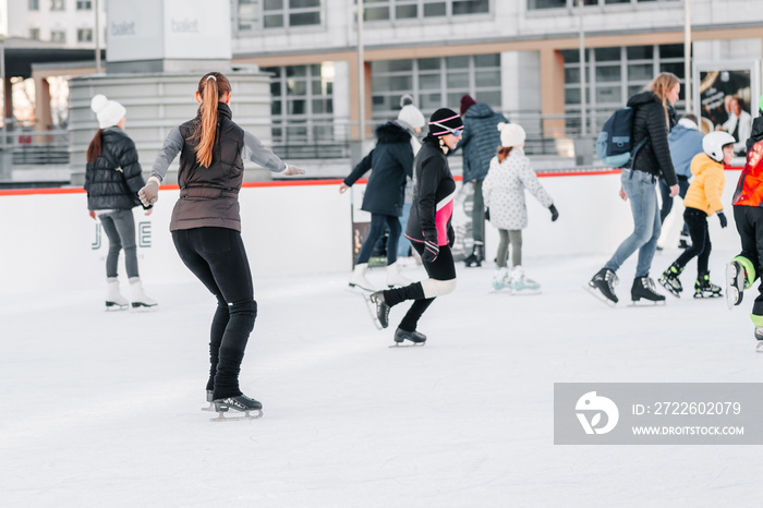 Soft,Selective focus.People, friendship, sport and leisure concept - happy friends on skating rink.Group of teenage friends ice skating on an ice rink