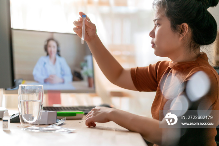 asian female hand nasal swab testing rapid tests by herself for detection of the SARS co-2 virus by tele video doctor instruction at home, isolate quarantine concept