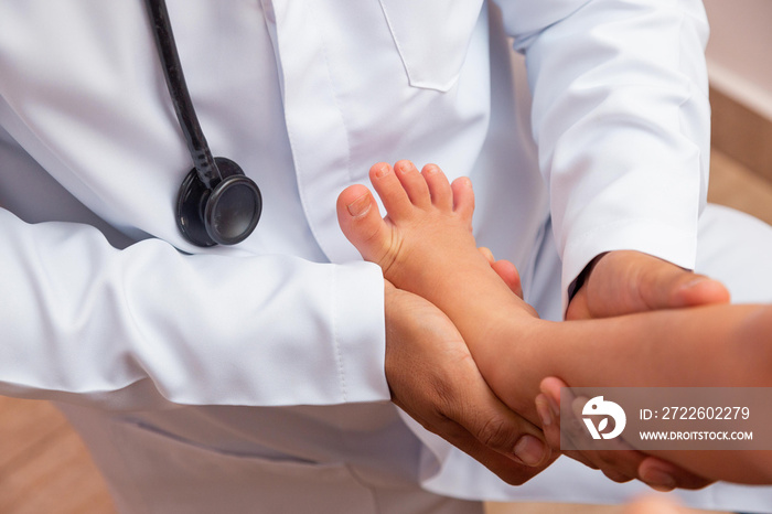 doctor examining children’s feet in hospital. Surgeon, traumatologist or orthopedist palpating girl’s leg and foot