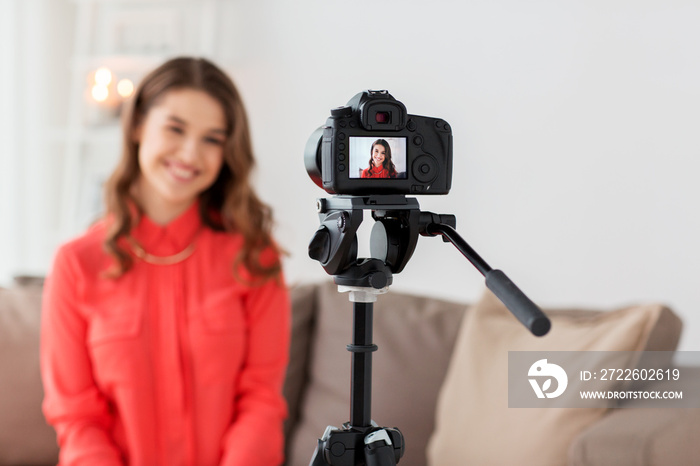 woman with camera recording video at home