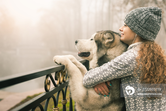 Image of young girl with her dog, alaskan malamute, outdoor