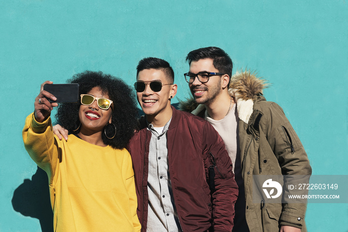 Group of happy friends taking a selfie in the street.