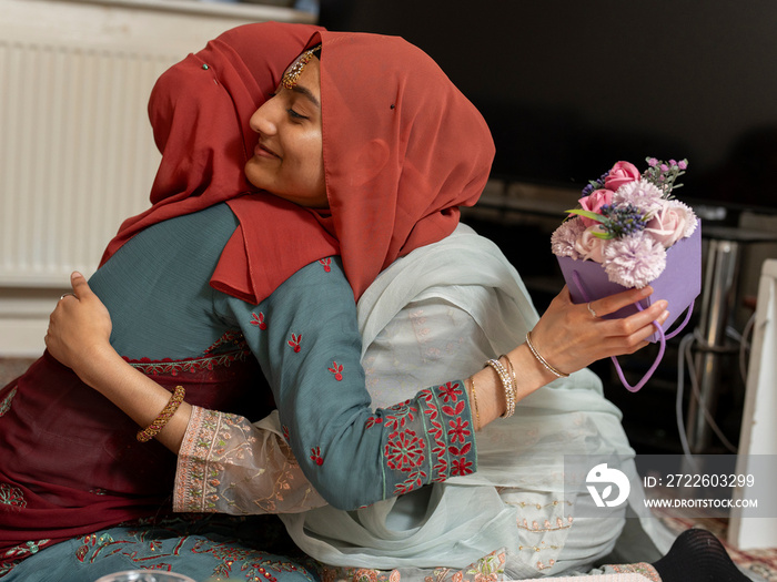 Women hugging each other during Ramadan celebration at home