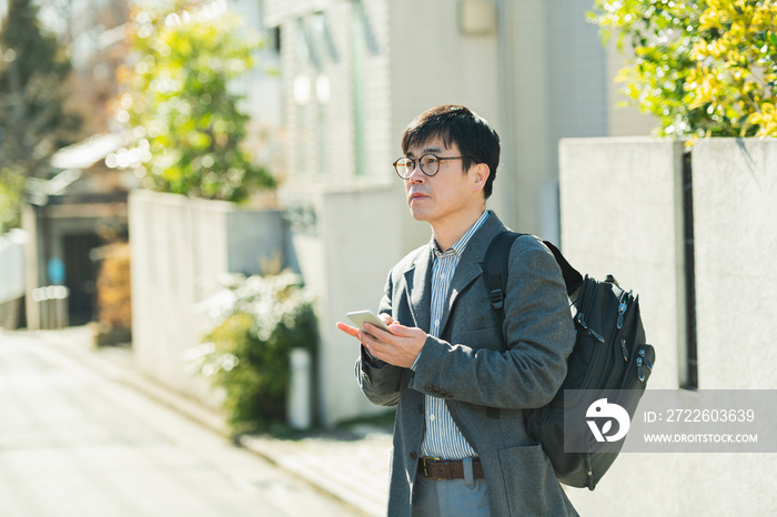 散歩中に携帯電話を見る男性