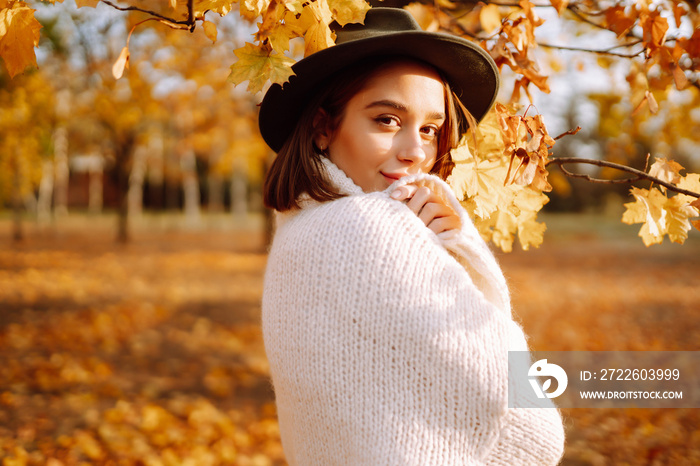 Stylish woman enjoying autumn weather in the park. Fashion, style concept.