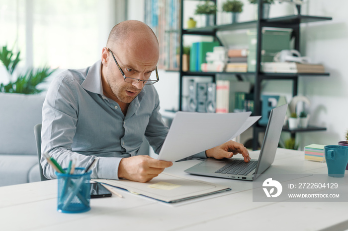 Disappointed businessman checking a financial report