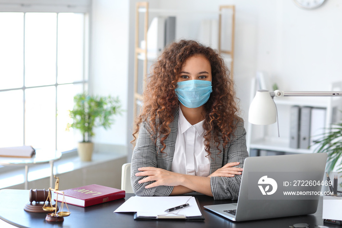 Female lawyer in protective mask working in office