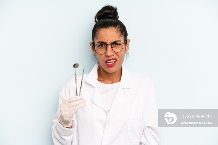 hispanic woman feeling puzzled and confused. dentist concept