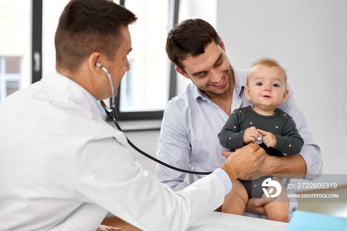 medicine, healthcare, pediatry and people concept - father with baby and doctor with stethoscope at medical office in hospital