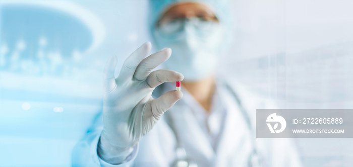 Medicine doctor holding a color capsule pill in hand with white glove in laboratory background