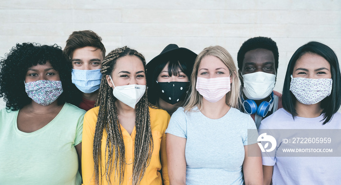 Young multiracial people wearing protective masks during coronavirus outbreak - Social distance between friends concept - Main focus on girl with yellow t-shirt face