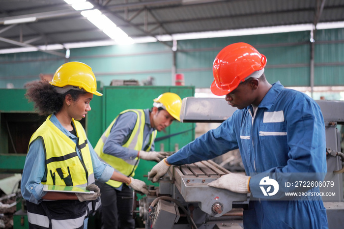 Team maintenance engineers men and women inspect relay protection system with laptop comp. They work a heavy industry manufacturing factory.