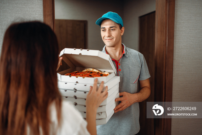 Delivery man shows pizza to customer at the door