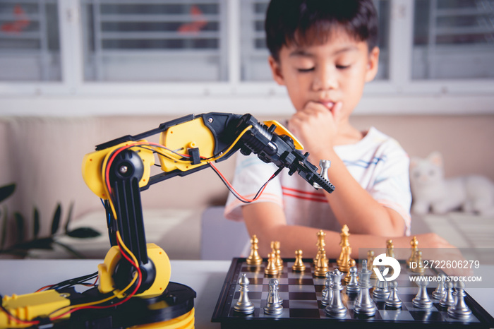 Asian little boy thinking and wait robot arm playing chess, STEM education E-learning, Funny children learning successful getting a lesson control robot arm game, Technology science education concept