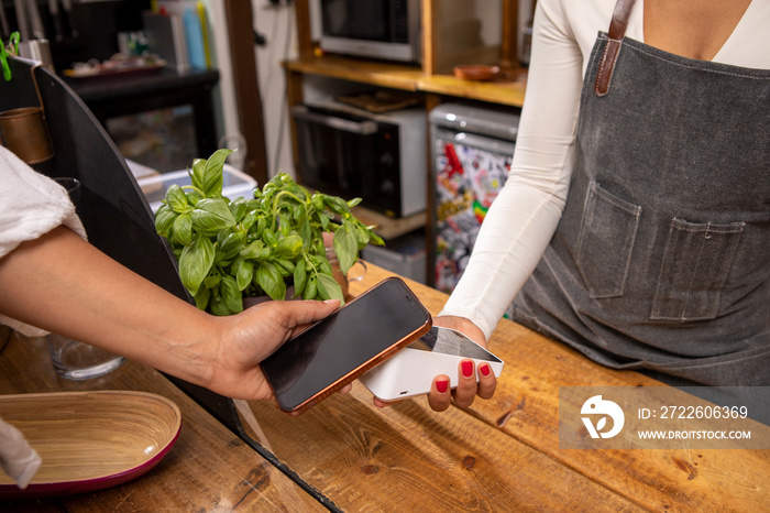 UK, London,�Close-up�of customer paying with smart phone at cafe