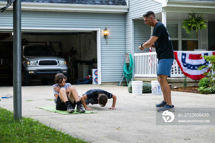 Air Force service member trains with his sons in a morning workout in preperation for a PT fitness test.