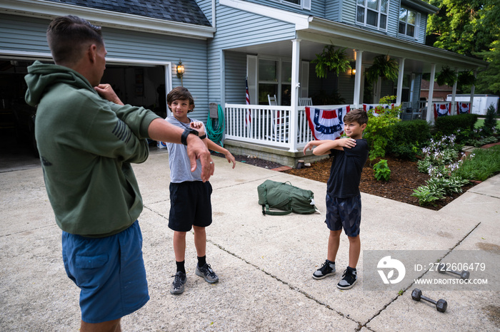 Air Force service member trains with his sons in a morning workout in preperation for a PT fitness test.