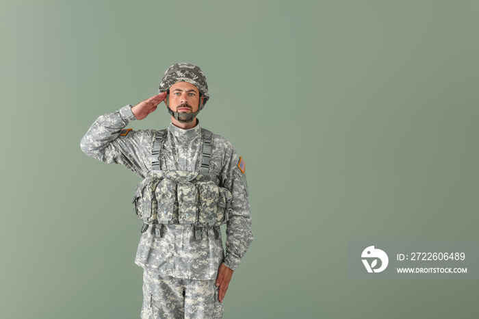 Saluting soldier on color background