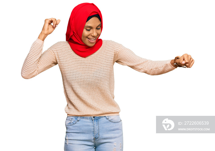 Young african american woman wearing traditional islamic hijab scarf dancing happy and cheerful, smiling moving casual and confident listening to music