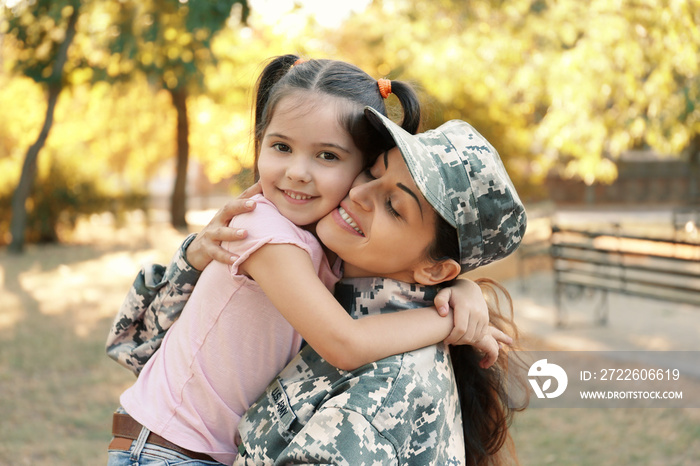 Woman in army uniform and her daughter in park