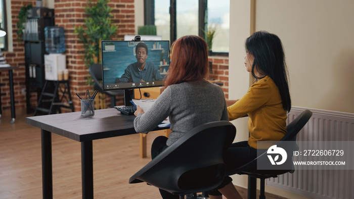 Coworkers using video call on computer to talk to candidate at job interview. Asian women attending remote meeting with applicant on video teleconference to discuss hiring and intern contract.