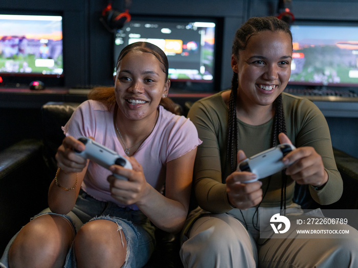 Female friends playing video games in gaming club