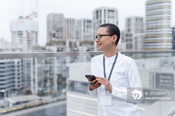 Non binary office worker posing against office buildings