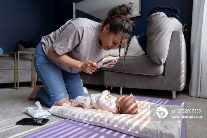 Mother showing contrast cards to newborn baby girl at home