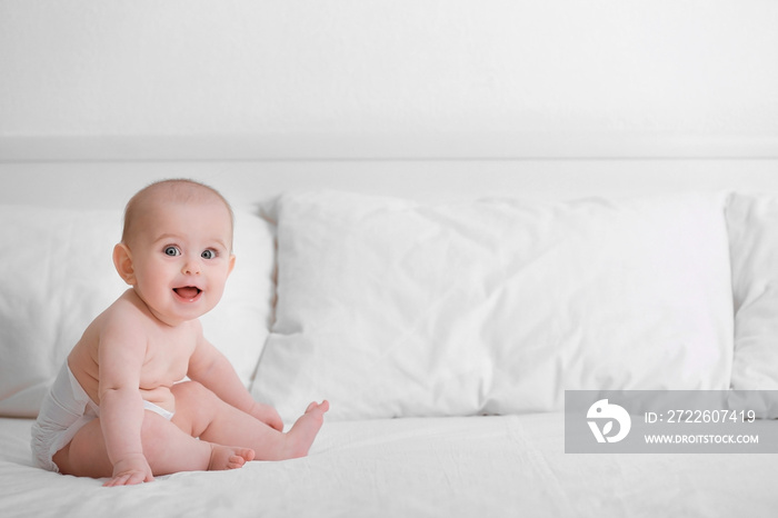 Cute funny baby sitting on bed at home