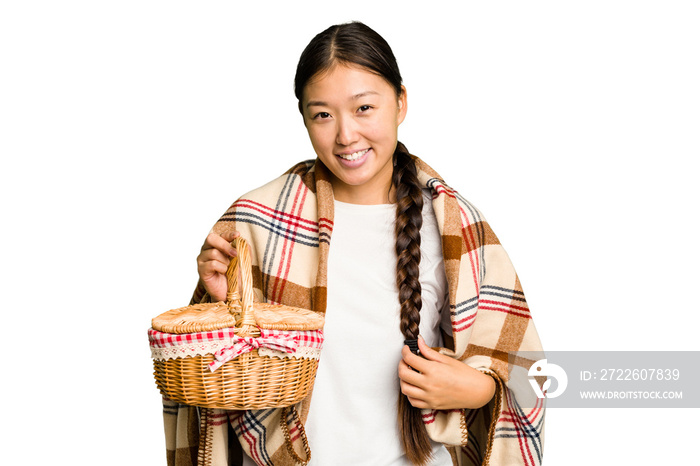 Young asian woman holding a picnic basket isolated happy, smiling and cheerful.