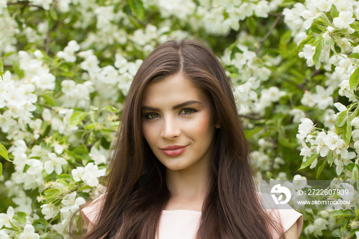 Nice woman in wreath of flowers. Beautiful female model enjoying spring nature and harmony