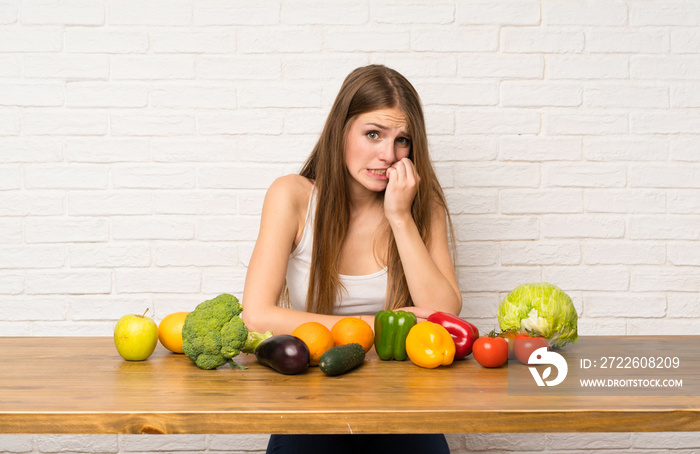 Young woman with many vegetables nervous and scared