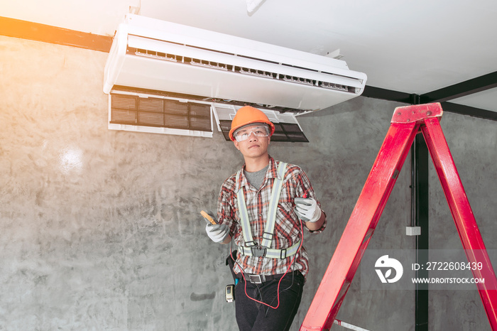 Air technician in the standard set of safety Checking the quality of the newly installed air conditioner.