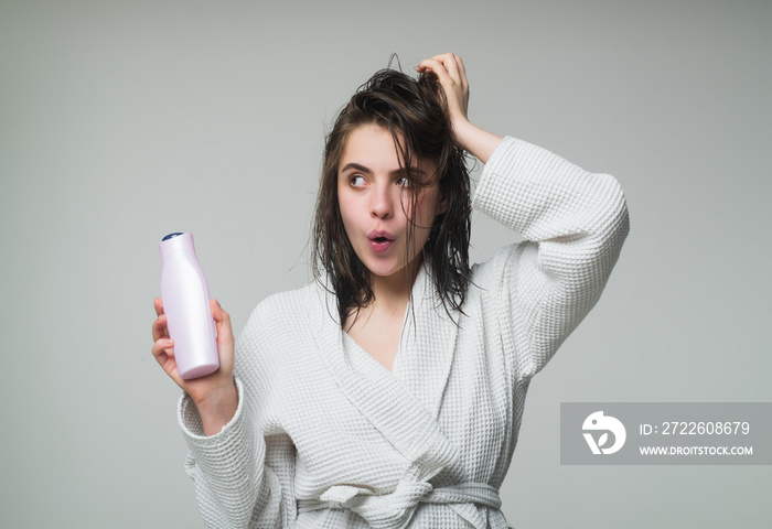 Woman touching her hair. After showering. Woman hold bottle shampoo and conditioner.