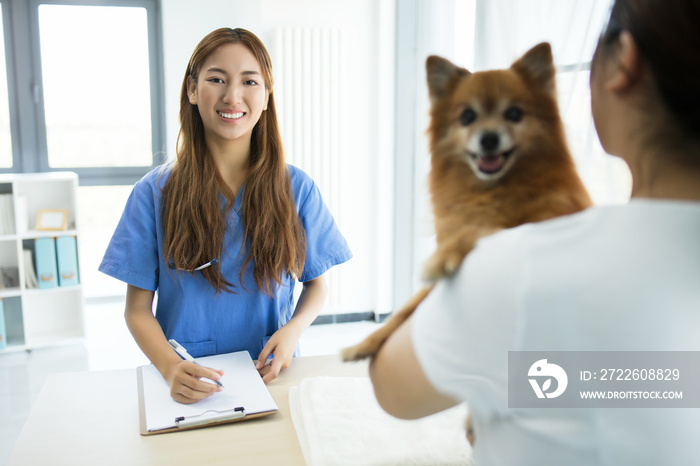 woman veterinarian holding a puppy