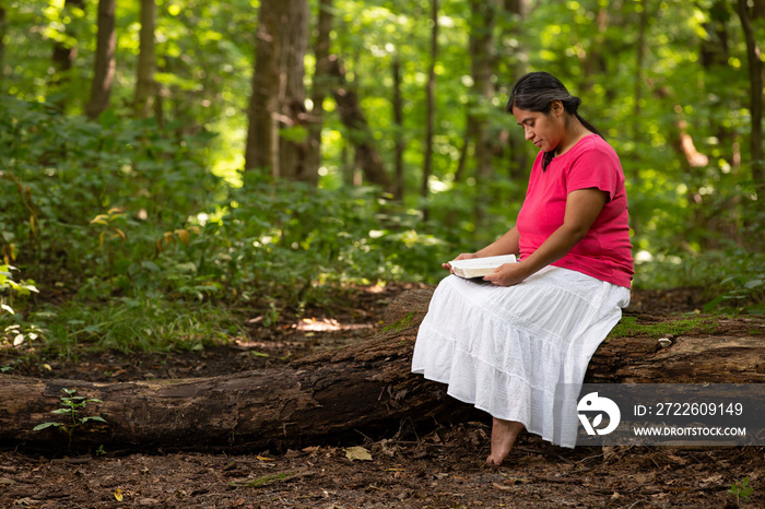 Hispanic Woman Meditating on Her Bible Reading in Forest Preserve