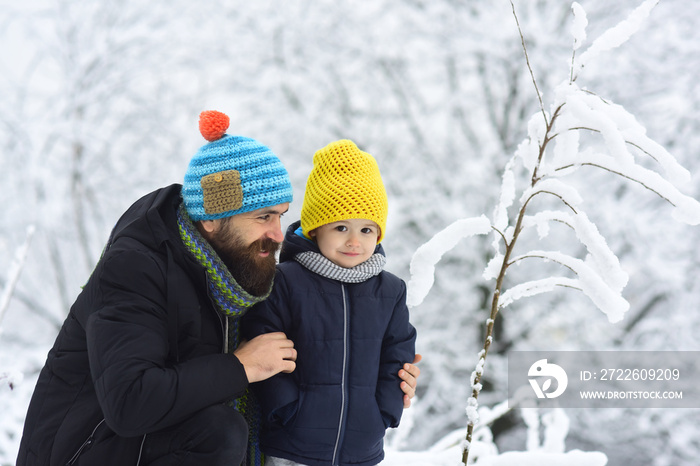 Winter family fun. Father and son playing in the park at winter time. People having fun on nature, snowy forest. Concept of friendly family, spending vacation together.