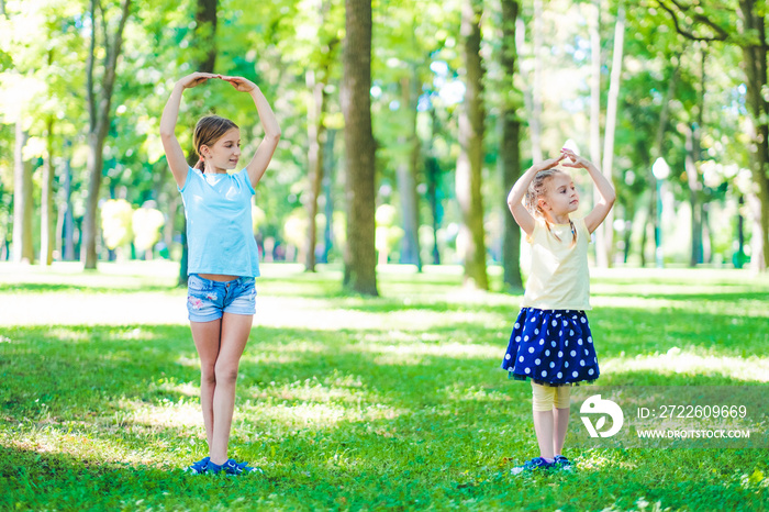 Little girls in park standing in dancing position