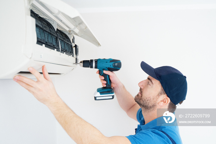 Technician installing air conditioner on the wall at home for hvac service