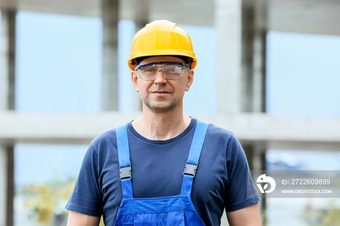 Male worker with safety hardhat and glasses at construction site