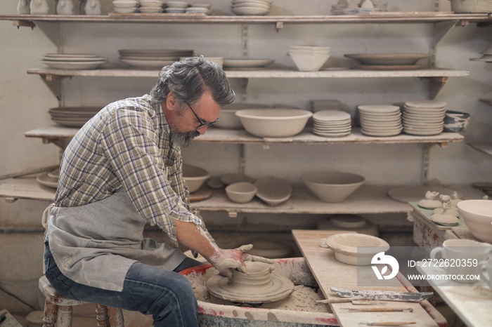 Male potter molding a clay