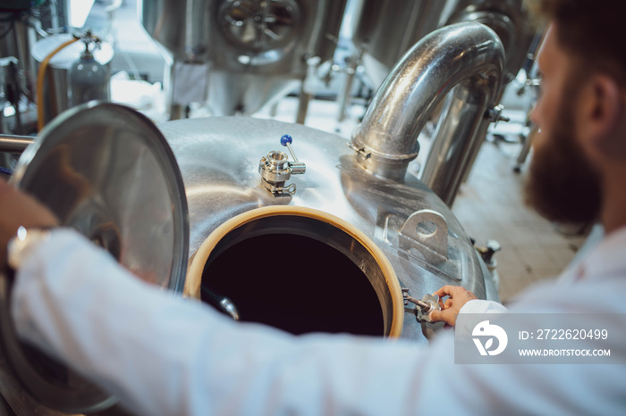 Professional caucasian technologist expert controlling industrial process in production plant. Industrial worker with protective uniform checking productivity in food factory.