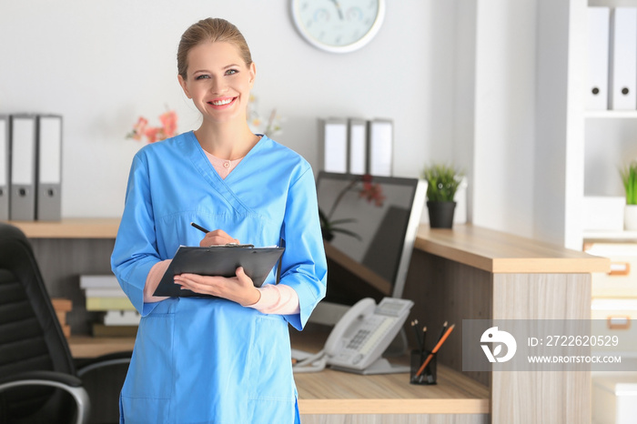 Young female receptionist holding folder with documents in hospital