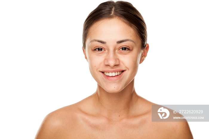 Portrait of young beautiful smiling woman with no makeup on white background