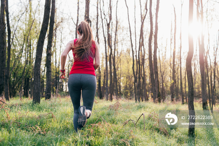 Rear view of young woman running outdoors