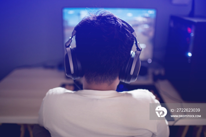 Portrait of asian boy gamer playing games on computer in the room at home