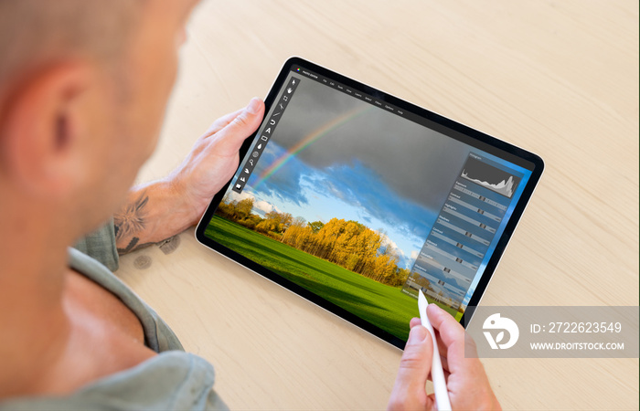 Man editing photo on tablet computer