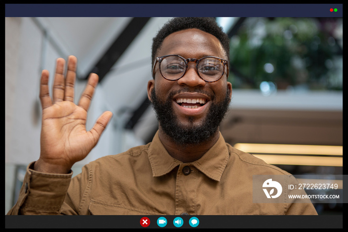 Smiling man waving in video call