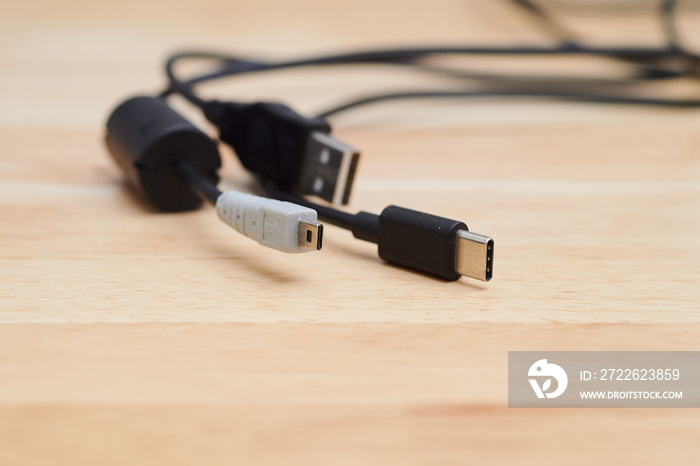 several charging cables lying on a table, including USB A  2.0 and USB C and AV cable